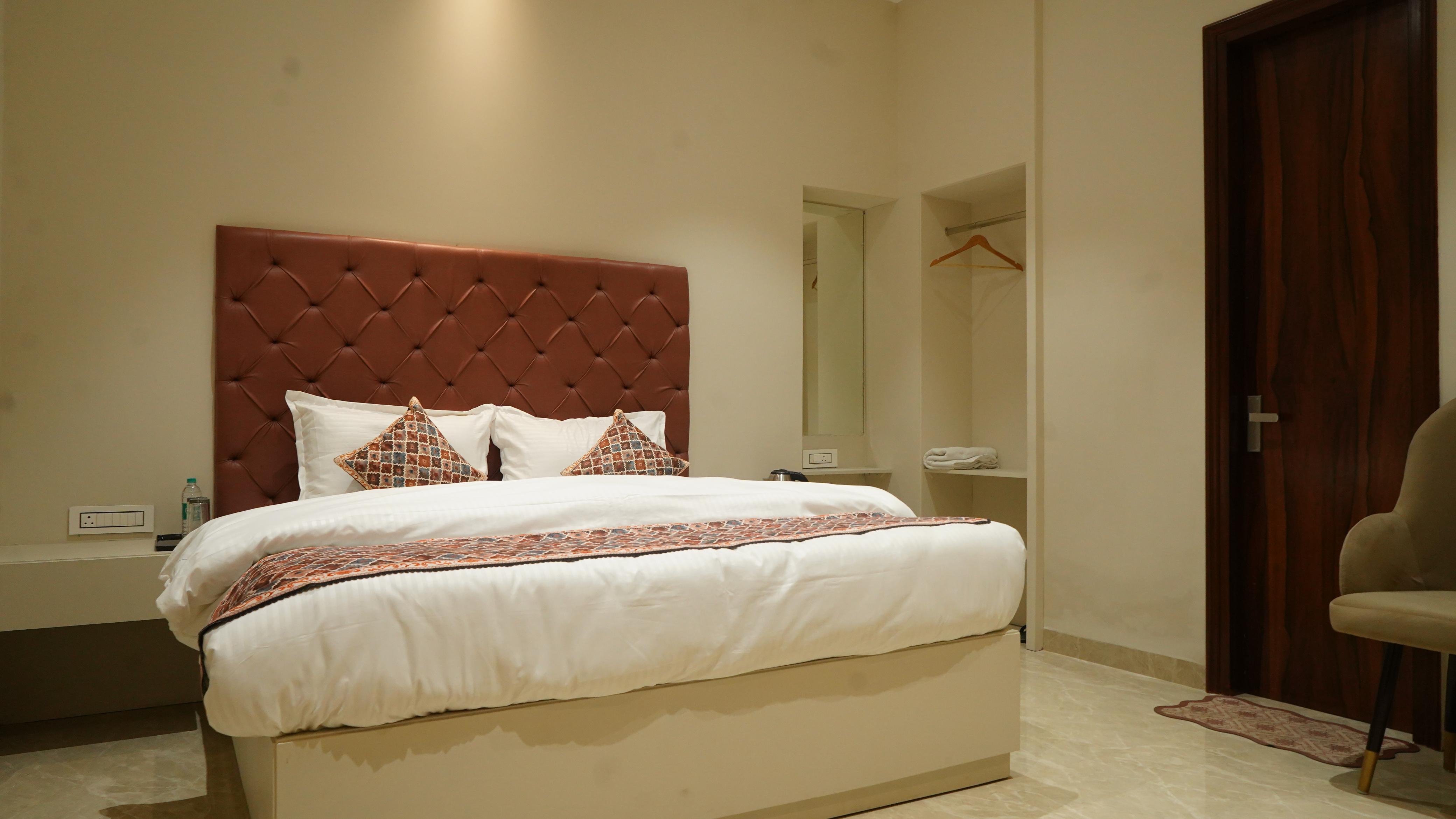 Luxury hotel room at THE ROYAL KING Ludhiana with white bedding and warm lighting